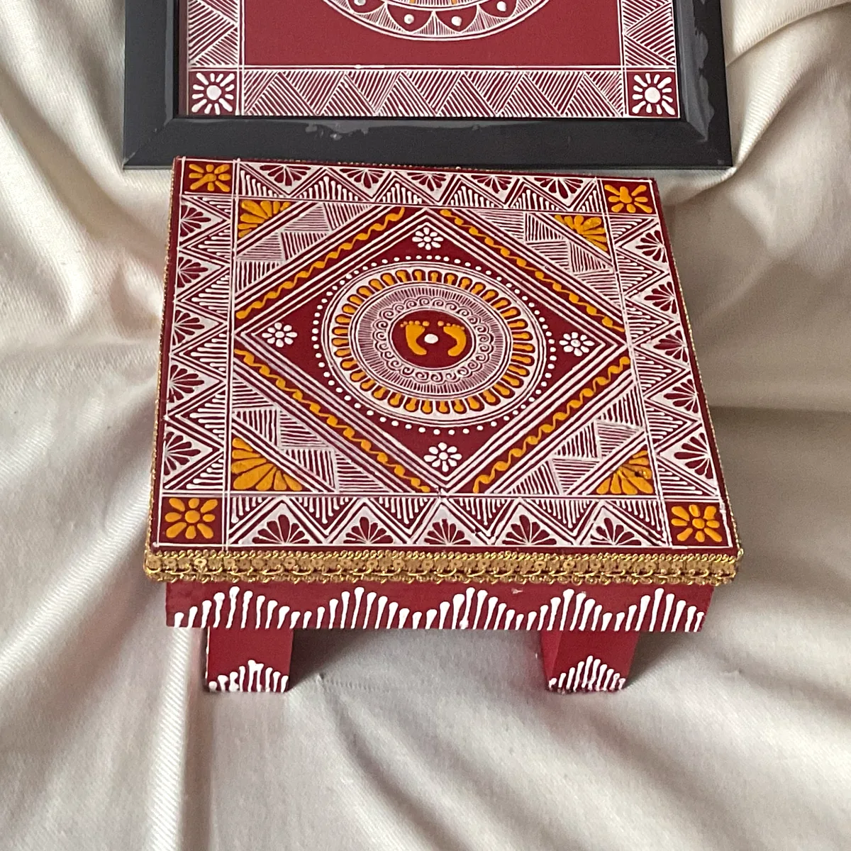 A wooden chowki painted with Aipan